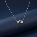 "Sparkling sterling silver Princess Crown Pendant Necklace with cubic zirconia stones on a white marble background."