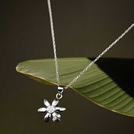 Silver flower pendant necklace with a crystal-studded center and petal design, displayed