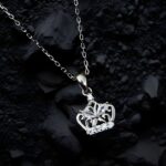 Close-up of a silver crown pendant necklace featuring marquise stones, floral detailing