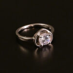 Radiant Elegance Sterling Silver Solitaire Ring with a brilliant sparkling stone on a black background.