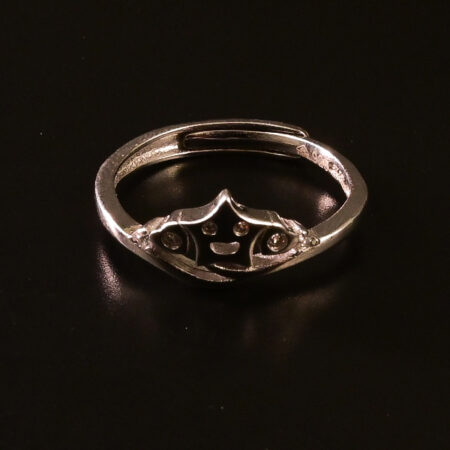 "Sterling silver ring featuring a crown design with a smiley face at the center, displayed on a dark background."