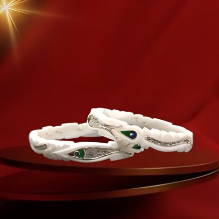 Pair of white traditional bangles featuring silver fish motifs with green and blue enamel detailing.
