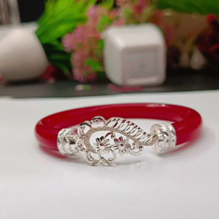 Elegant red jade bangle bracelet with intricate silver floral centerpiece, handcrafted jewelry design.