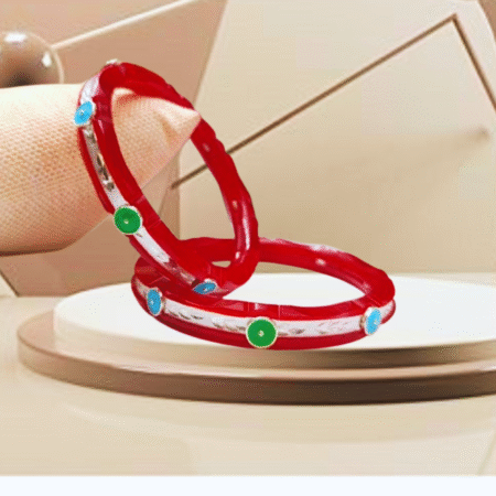 Pair of silver bangles with red enamel, adorned with blue and green circular stones