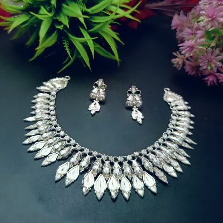 Oxidized silver necklace and earring set with intricate mirror drop detailing and traditional Indian motifs, displayed on a dark background.