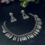 Tribal silver-plated necklace set featuring multiple teardrop and bullet-shaped charms with matching long dangle earrings, displayed on a dark background.