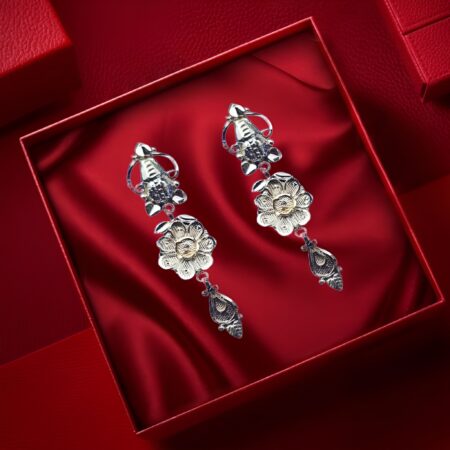 Elegant silver dangle earrings with intricate floral design and teardrop charm