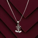 Silver flower locket pendant necklace with crystal-accented leaves on a fine silver chain, displayed on a black background.
