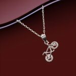 Silver bicycle locket pendant necklace with sparkling wheel detail on a fine silver chain, displayed on a black background.