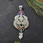 Intricately designed silver locket with floral and geometric patterns, featuring red, green, and blue enamel accents and a detailed hanging motif.