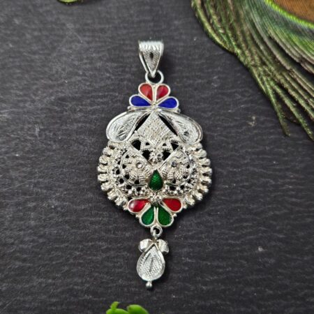 Intricately designed silver locket with floral and geometric patterns, featuring red, green, and blue enamel accents and a detailed hanging motif.