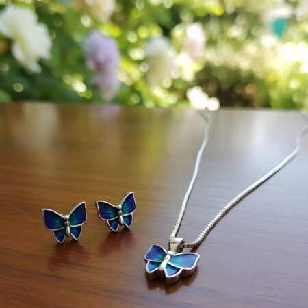 Silver butterfly jewelry set featuring a necklace with a blue and turquoise butterfly pendant and matching butterfly stud earrings.
