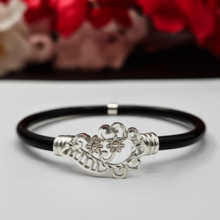 Elegant oxidized silver floral design bracelet with black band, featuring intricate flower and swirl detailing at the center.