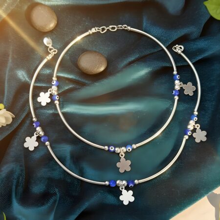 Silver women’s anklet with blue beads and floral charms displayed