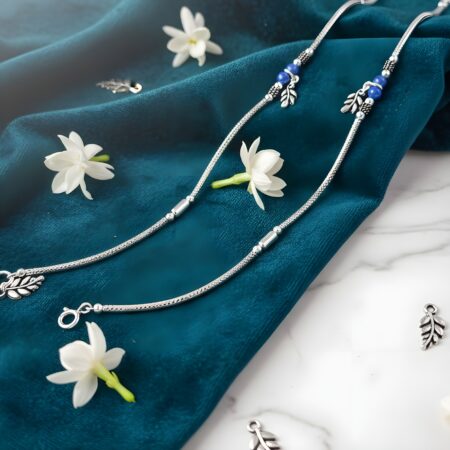 Elegant silver women anklet pair featuring blue beads and leaf charms.